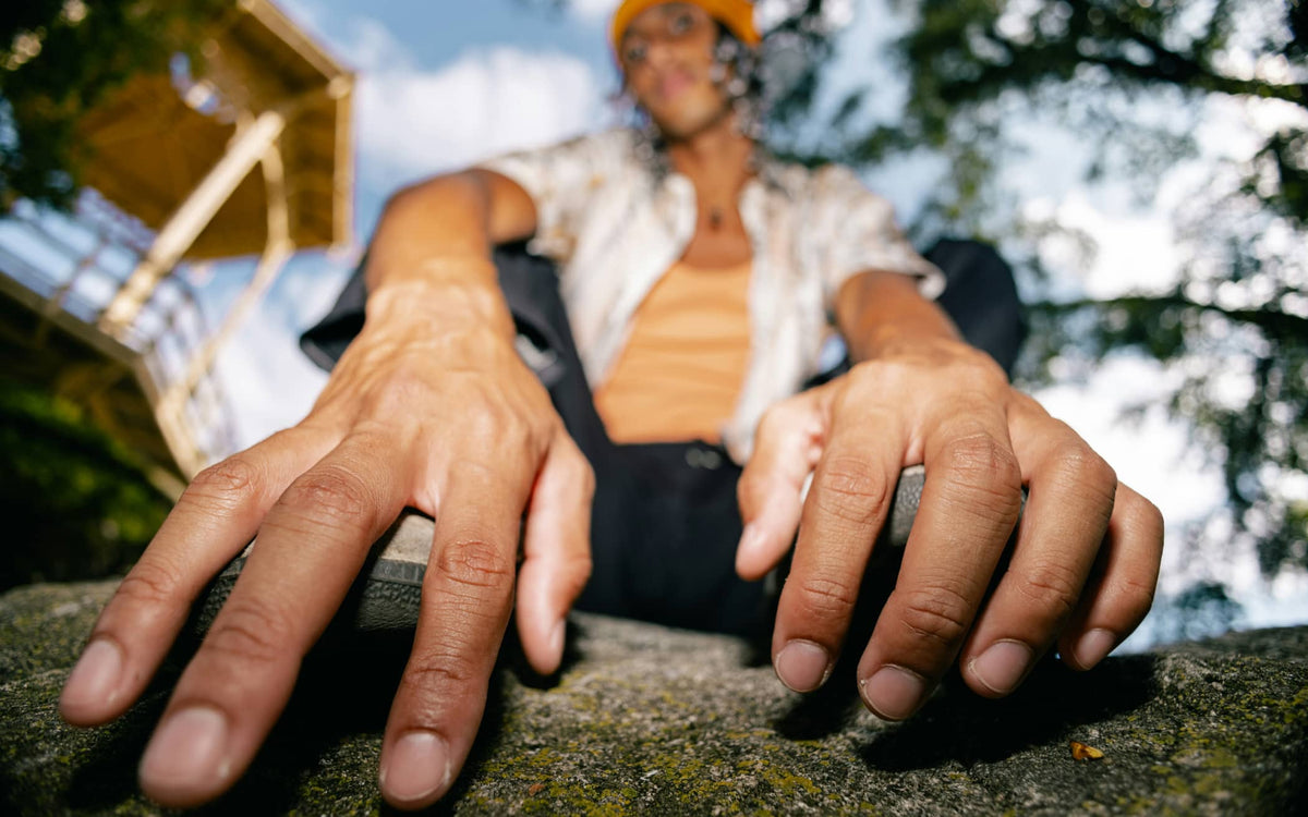 Low angle view of person resting hands on stone surface outdoors