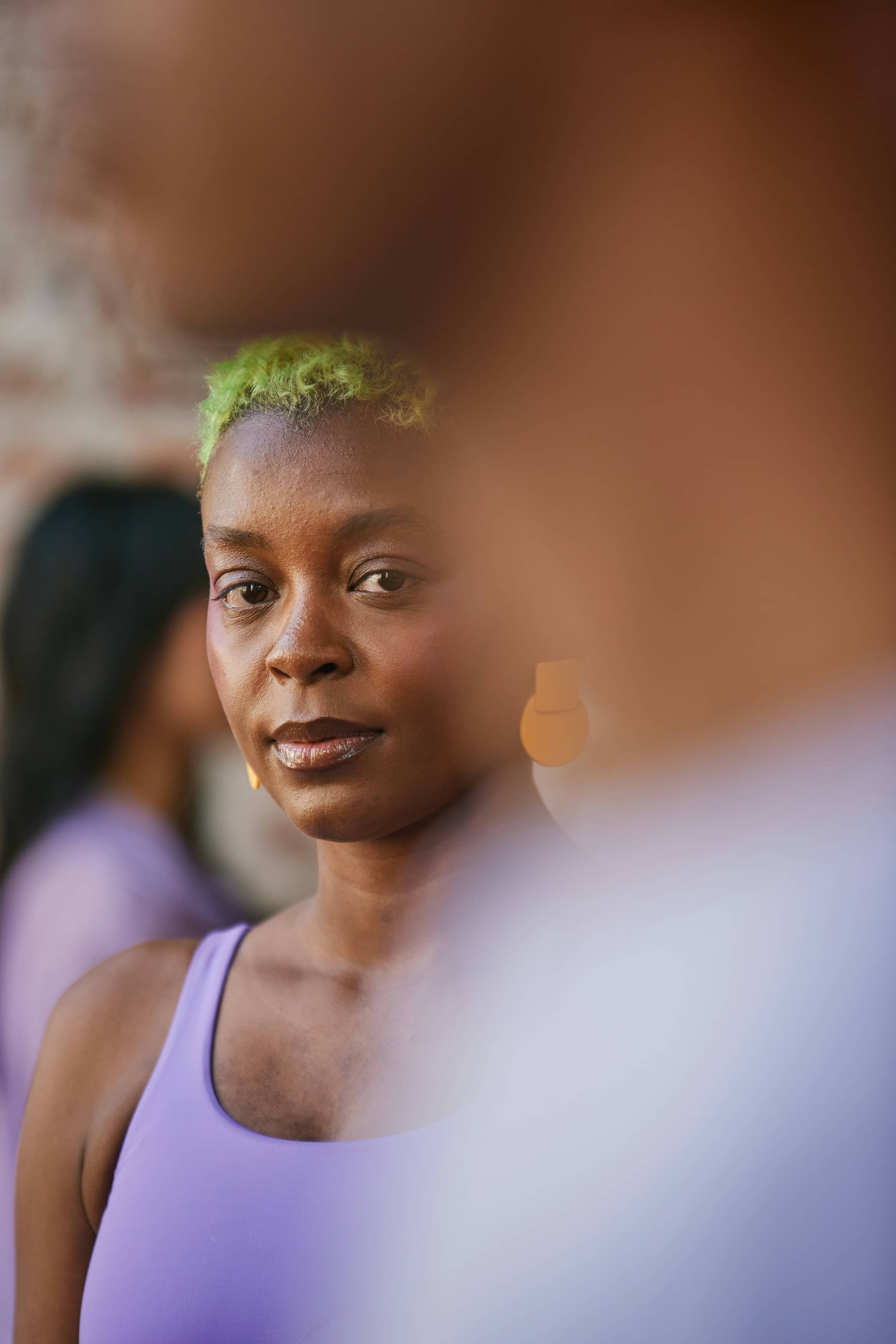 Portrait of woman with short green hair wearing purple top
